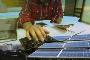 person using calculator to review solar panel installer quotes